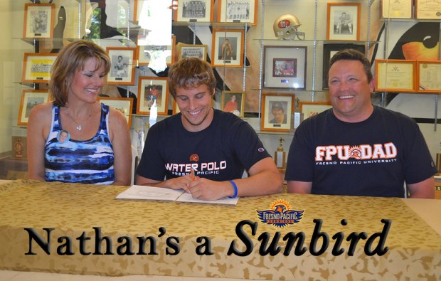 Nathan Olson, with Mom Heather and Dad Nathan at his signing ceremony.